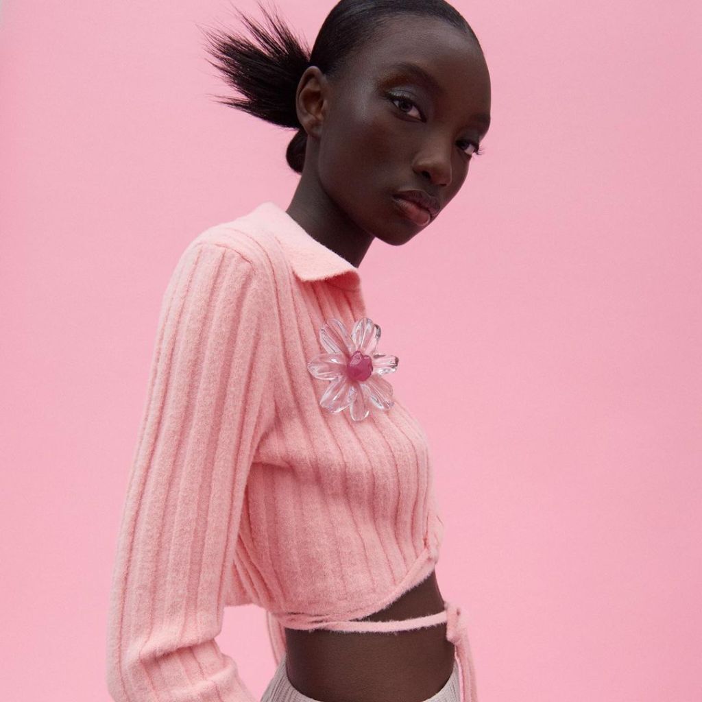 Zara model wears pink cardigan with large floral plastic broche.
