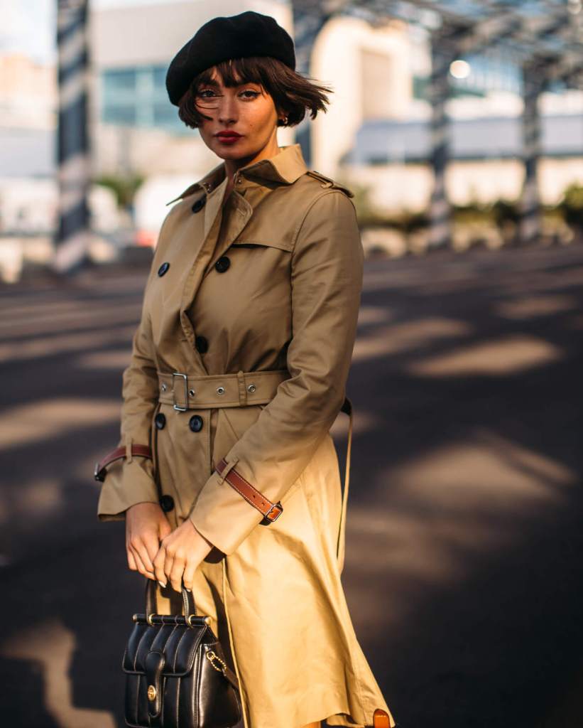 Woman wears camel trench coat at new york fashion week 2021