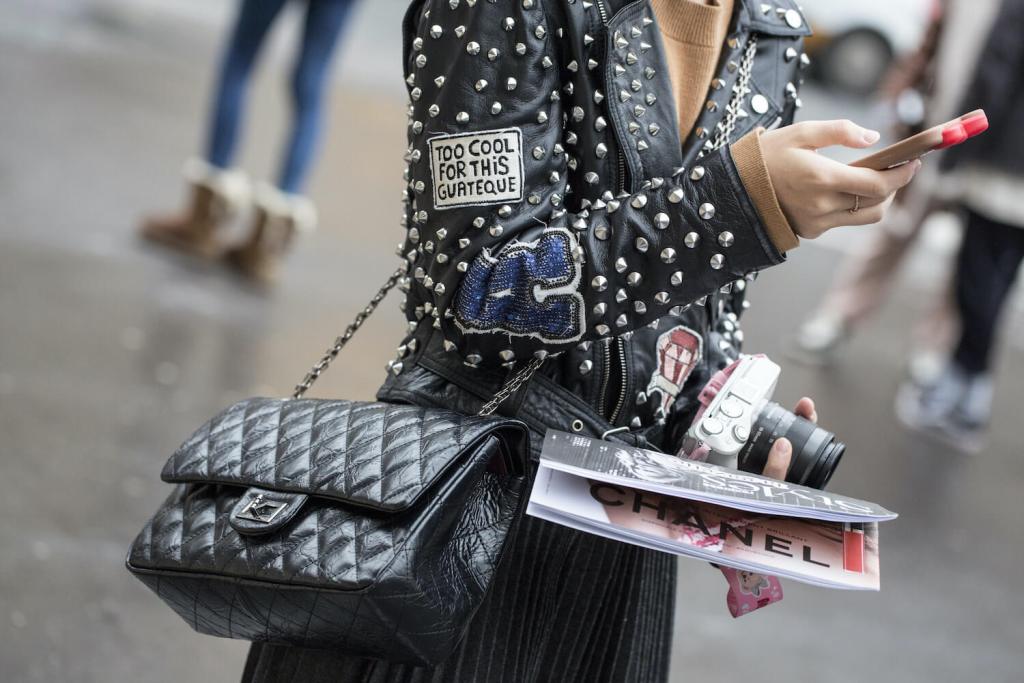 woman wears chanel bag and leather studded jacket