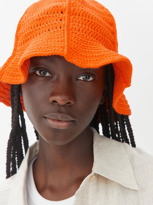 Woman wears orange hat from Arket