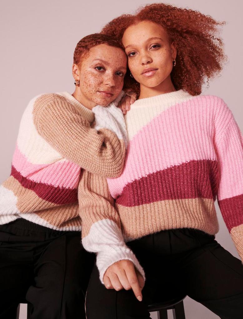 Two light-skinned black women with freckles wear striped M&S jumpers
