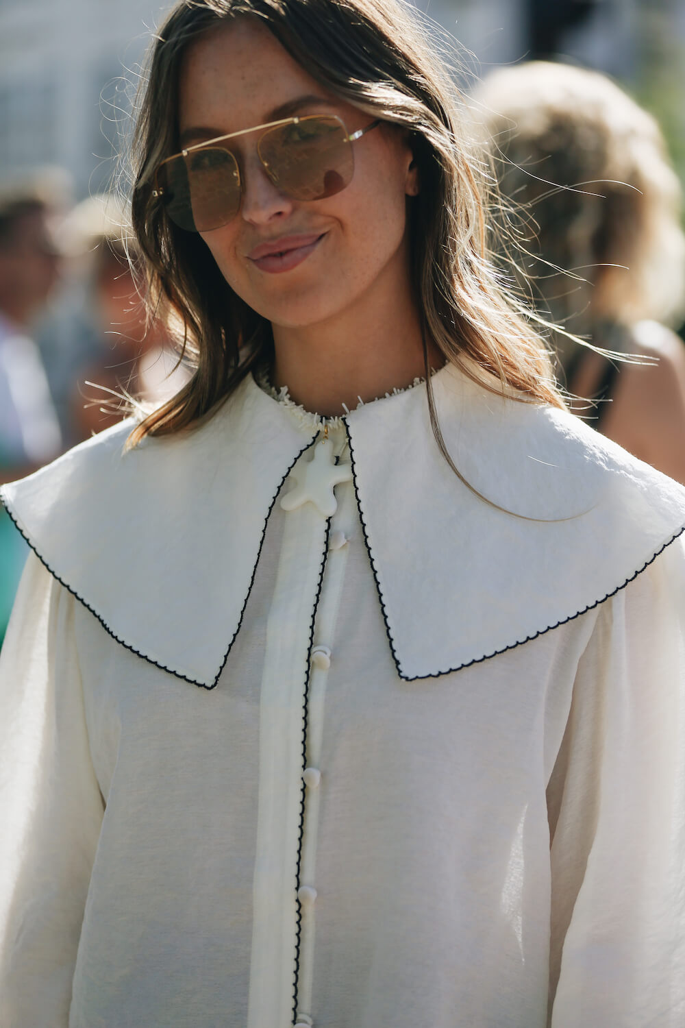 woman at copenhagen fashion week wearing white shirt and sunglasses