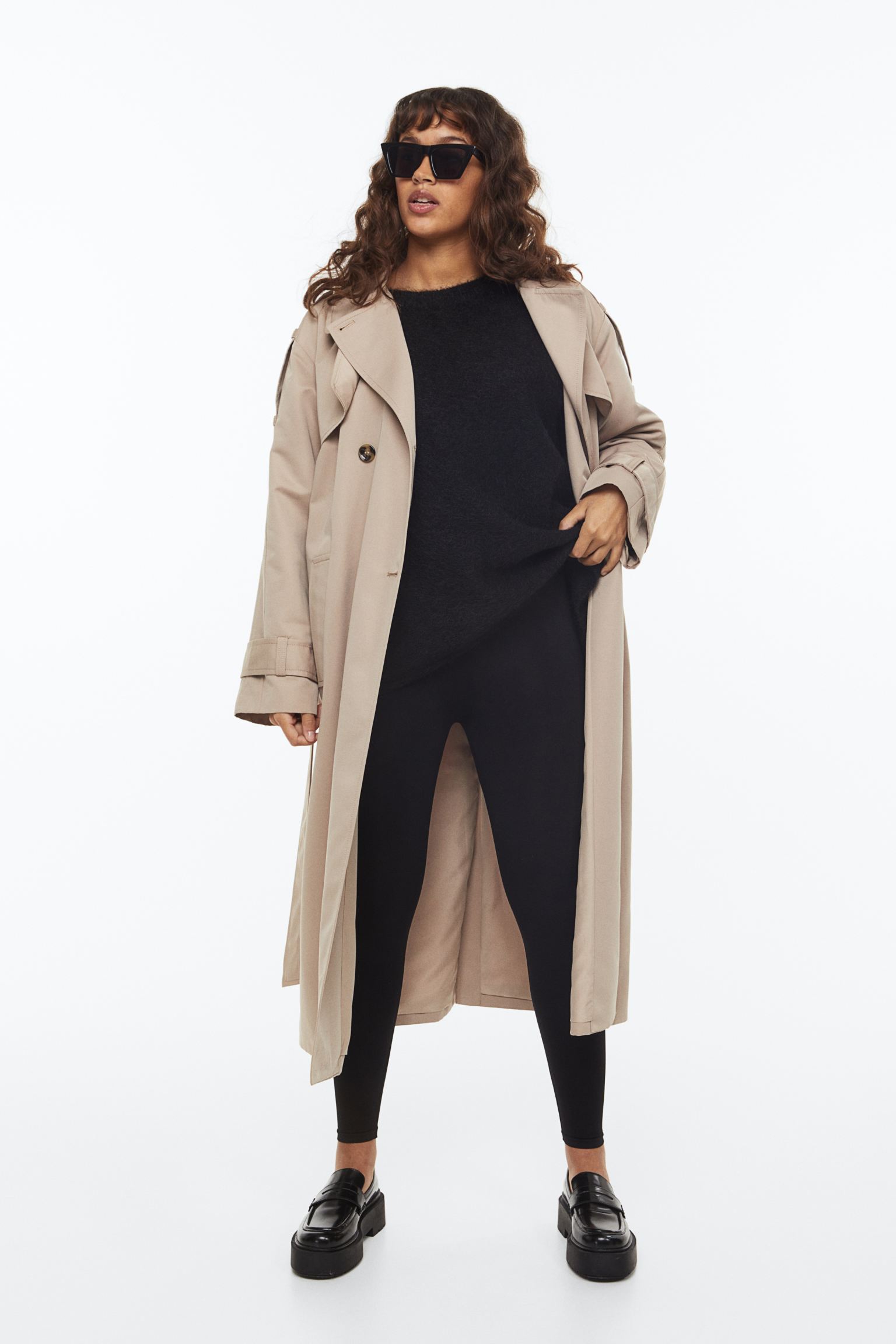 Model wearing black leggings, oversized shirt and a trench coat from H&M