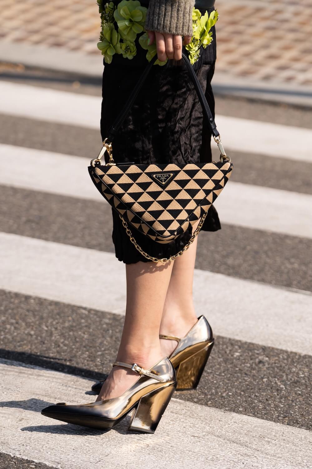 woman wearing triangular print pattern Symbole Mini bag from Prada and metallic shoes