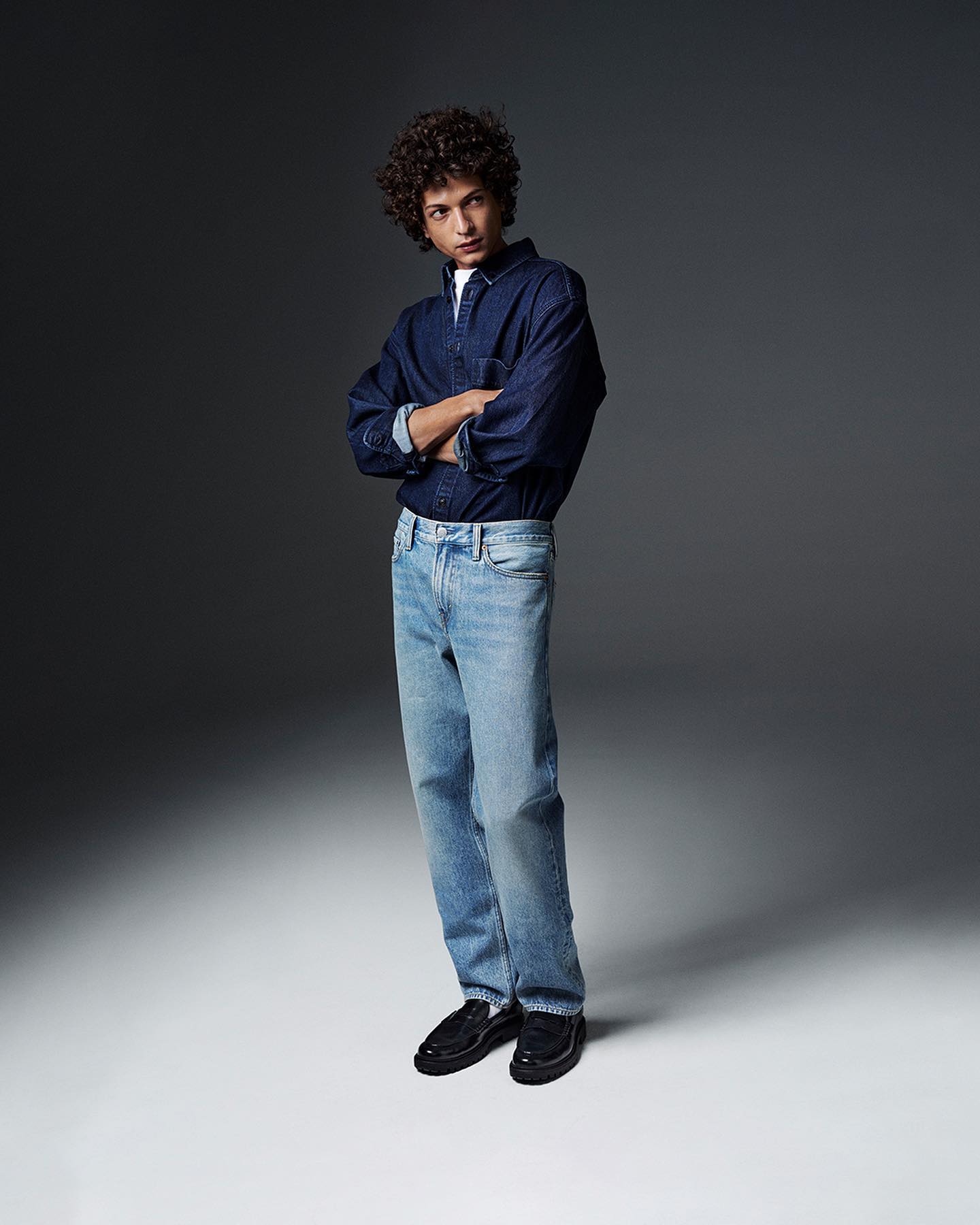 H&M man model wears the Relaxed jeans in blue denim