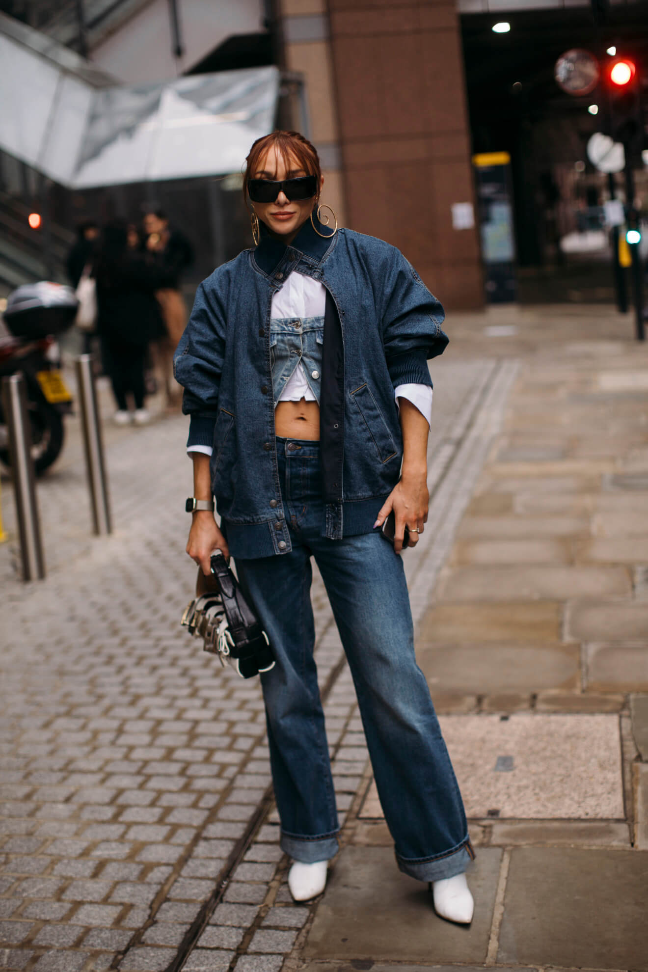 woman at fashion week wears boots with jeans